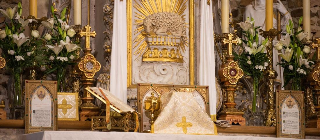 Le maître-autel de la chapelle orné de lys, avec le calice et l’Agneau doré